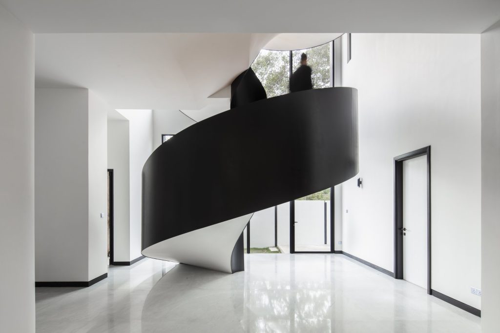 Fillet House: metal railing wrapping the concrete spiral staircase.