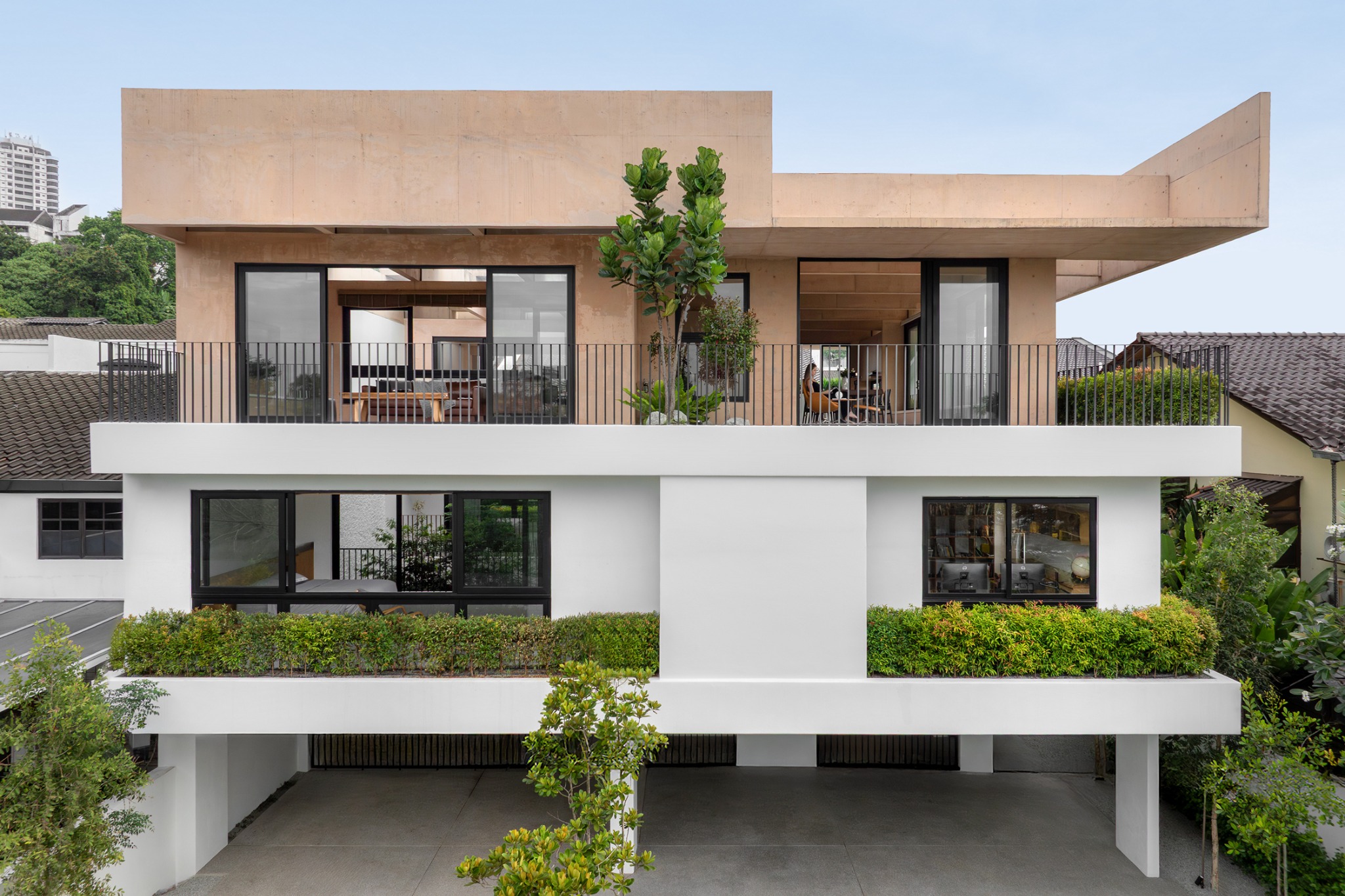 ARMOUA House: layered street facade, pink concrete beams and planted terraces.