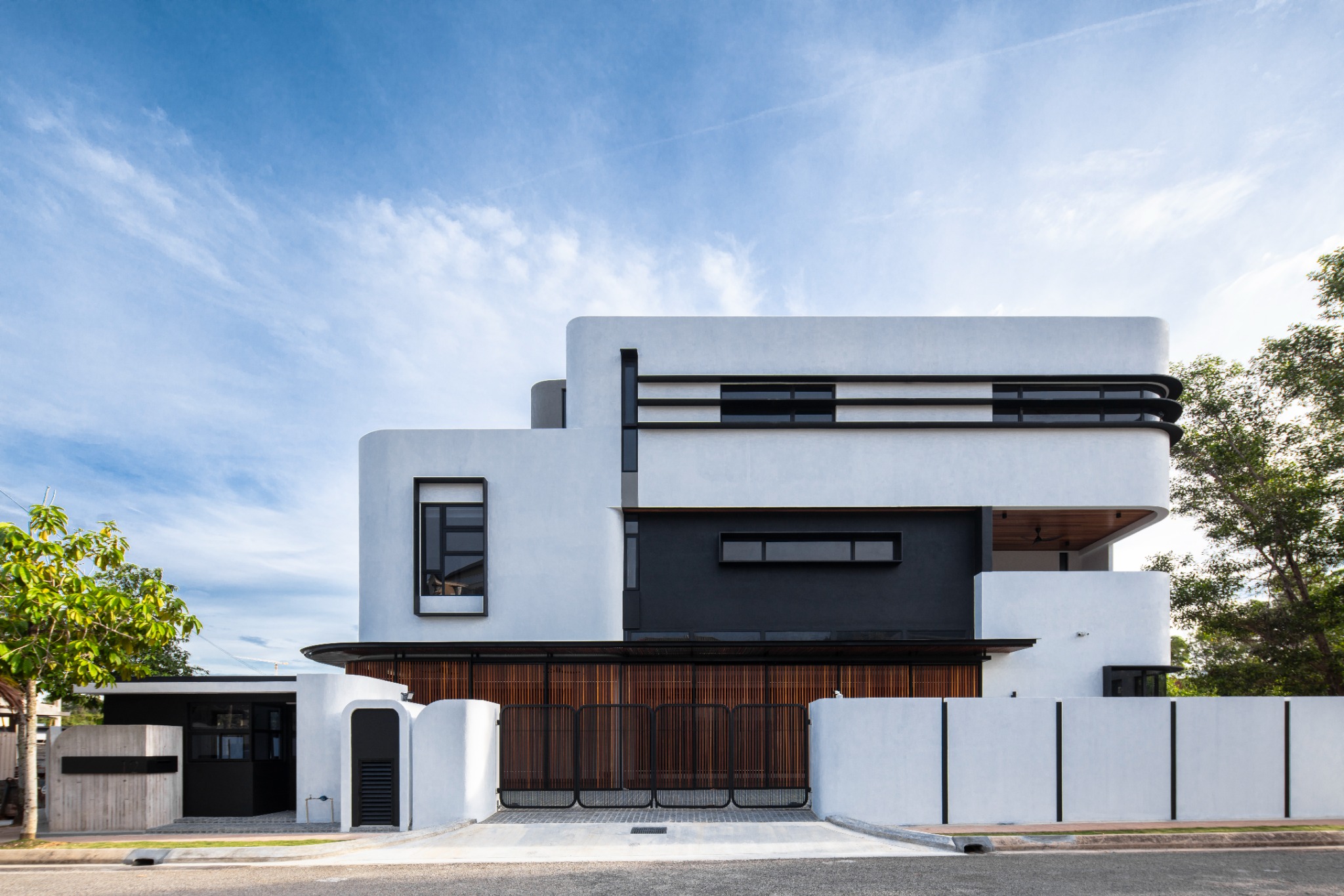 Fillet House: rounded white facade with dark horizontal shading and timber screens.